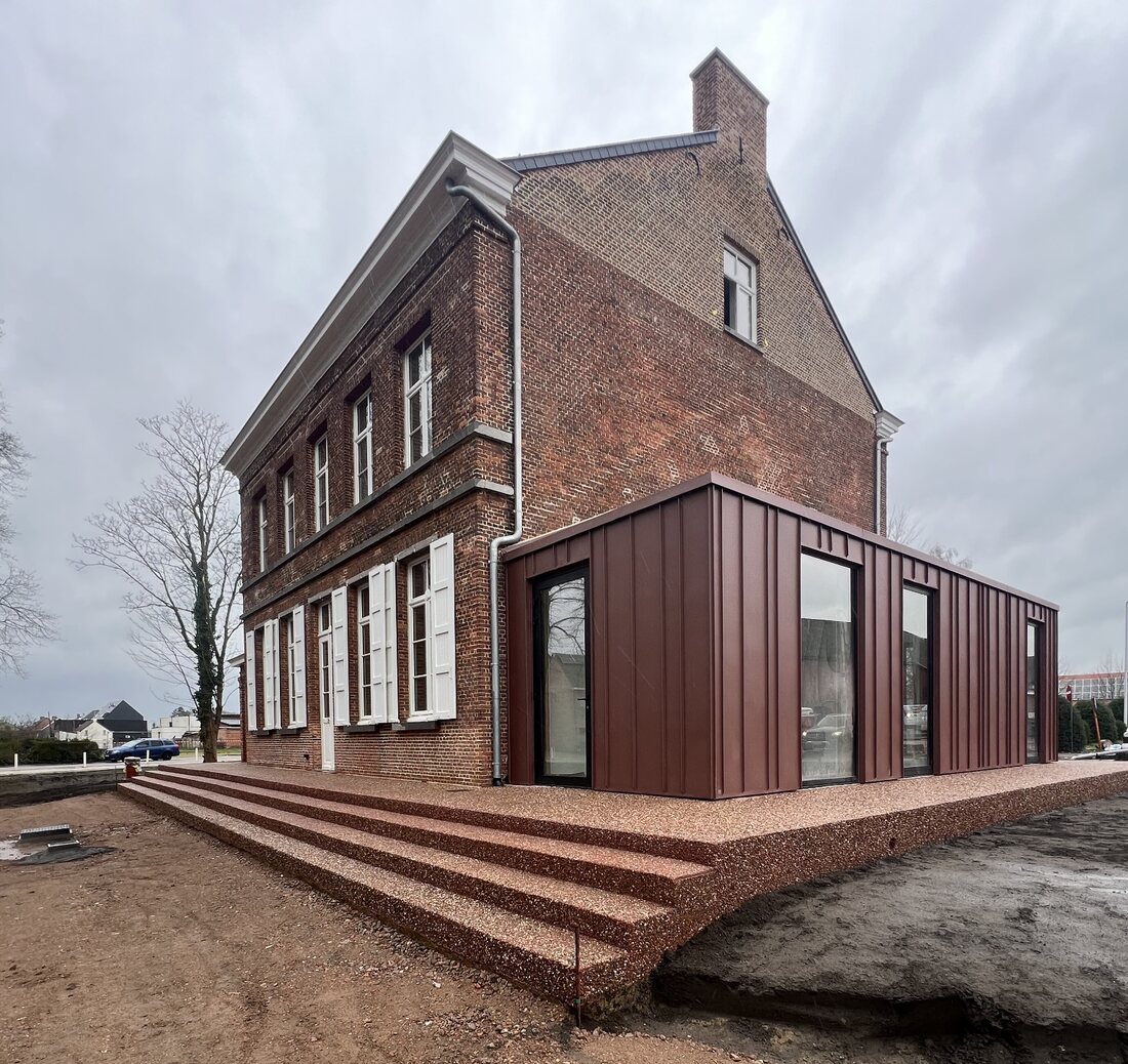 Uitgewassen betonnen terras en trappen rondom een gerenoveerde pastorijwoning